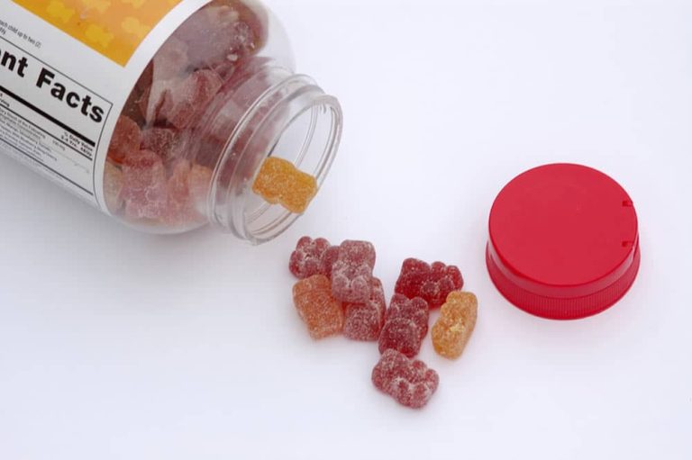 A jar of gummies spilling onto a white table